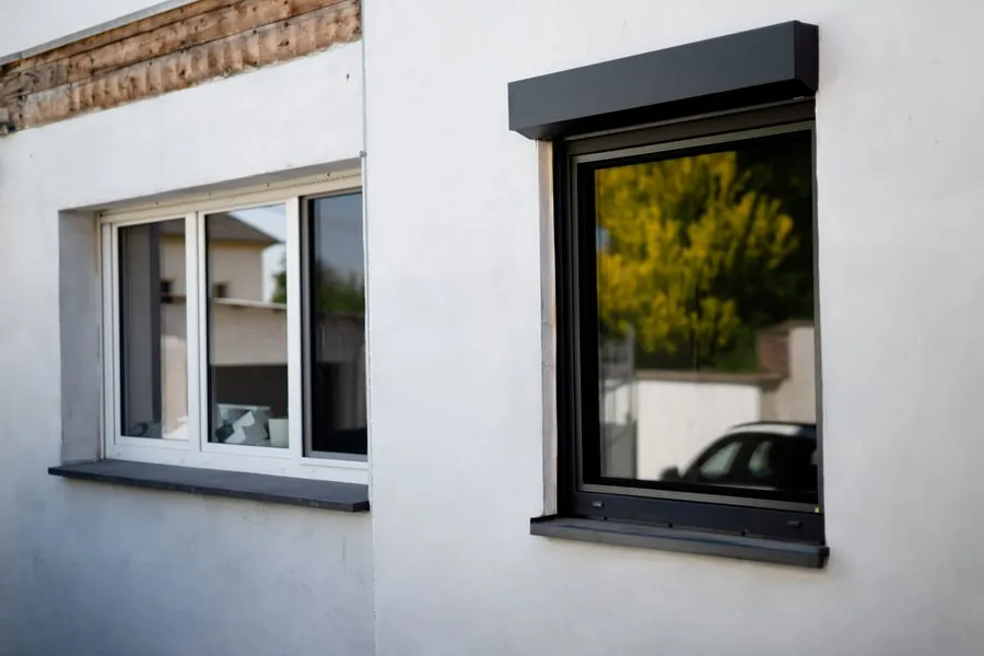 Weißes und schwarzes Fenster in heller Fassade
